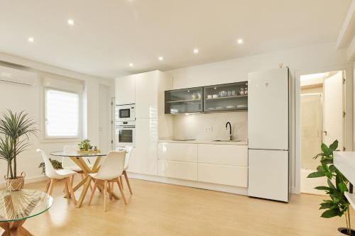 a kitchen with white cabinets and a table and chairs at Del Valle Hogar Centro in Córdoba