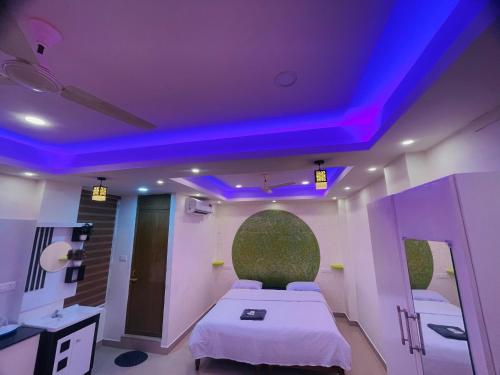 a room with a bed with a purple ceiling at Studio suites in Trivandrum