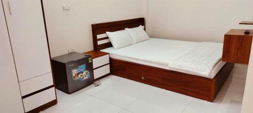 a small bedroom with a bed and a television at Catimor Hotel in Sầm Sơn