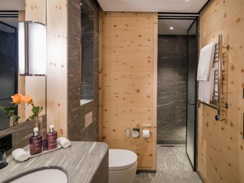 a bathroom with a toilet and a shower at Kulm Hotel St. Moritz in St. Moritz