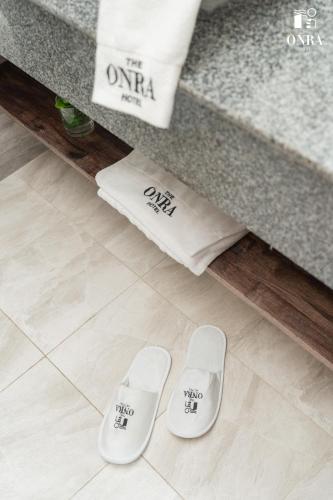 a pair of white slippers sitting next to a counter at The ONRA Hotel in Phnom Penh