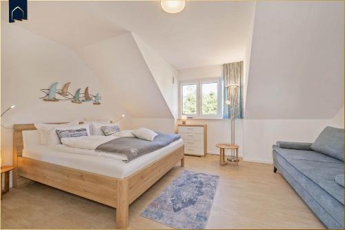 a bedroom with a bed and a blue couch at Ferienhaus Nordwind in Kolpinsee