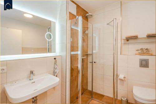 a bathroom with a sink and a shower at Ferienhaus Nordwind in Kolpinsee