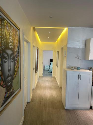 a hallway with a painting of a woman on the wall at Chic City Oasis at Gazebo in Addis Ababa