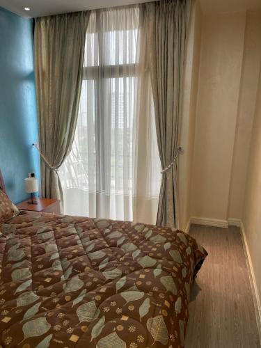 a bedroom with a bed and a large window at Chic City Oasis at Gazebo in Addis Ababa