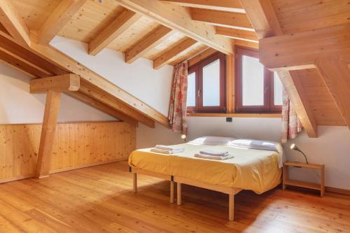 a bedroom with a bed in a room with wooden ceilings at Agriturismo Soleil Levant Torgnon in Torgnon