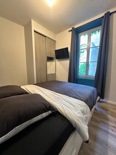 a bedroom with a large bed with a window at Chez Loy in Chamalières