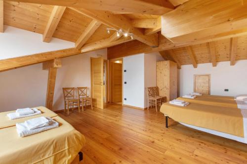 a bedroom with two beds and wooden ceilings at Agriturismo Soleil Levant Torgnon in Torgnon