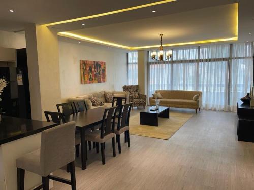 a dining room and living room with a table and chairs at Chic City Oasis at Gazebo in Addis Ababa