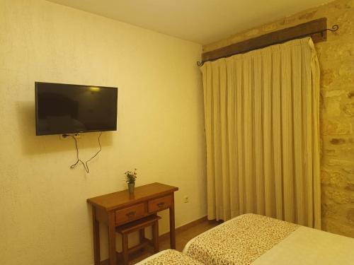 Una televisión o centro de entretenimiento en hostal Decerca Prádena