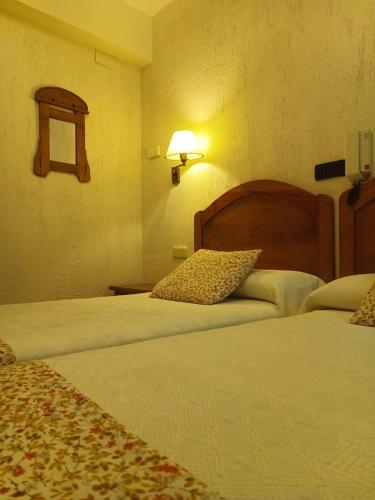 Una cama o camas en una habitación de hostal Decerca Prádena