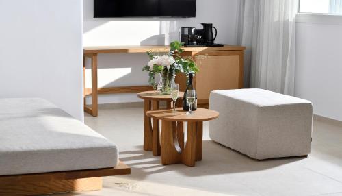 a living room with a chair and a table with a wine glass at Etere Luxury Suites in Agios Ioannis Mykonos