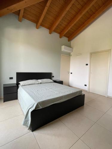 a bedroom with a large bed and a wooden ceiling at Apartment Murnera in Mozzate