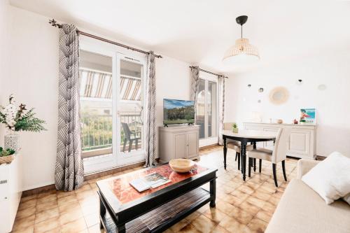 un salon avec une table et un canapé dans l'établissement SPÉCIAL COUPLE & FAMILLE - Lit Queen Size - Netflix - Climatisation - Terrasse Plein Sud - 2 min Centre-Ville - 6 min Mer - Parking privé - OFFRE SPÉCIALE, à La Londe-les-Maures