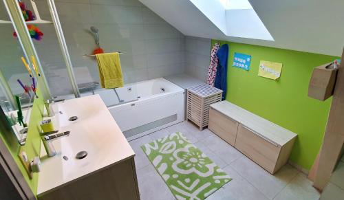 une petite salle de bain avec des murs verts et des armoires blanches dans l'établissement Maison familiale - Jardin, à Collonges-sous-Salève