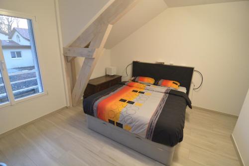 une chambre avec un lit dans une pièce avec une fenêtre dans l'établissement Maison familiale - Jardin, à Collonges-sous-Salève