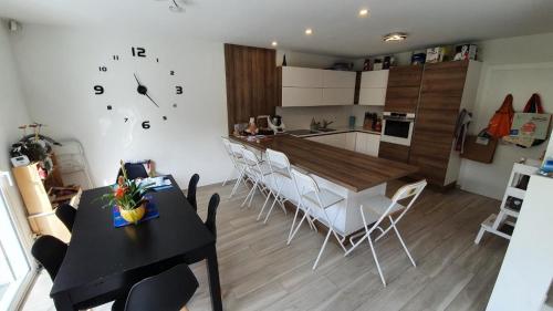 une cuisine et une salle à manger avec une table et des chaises dans l'établissement Maison familiale - Jardin, à Collonges-sous-Salève
