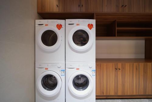 two washing machines and a washer and dryer in a kitchen at Yongchun Laimeng Garden Hotel in Yung-ch'un-hsien