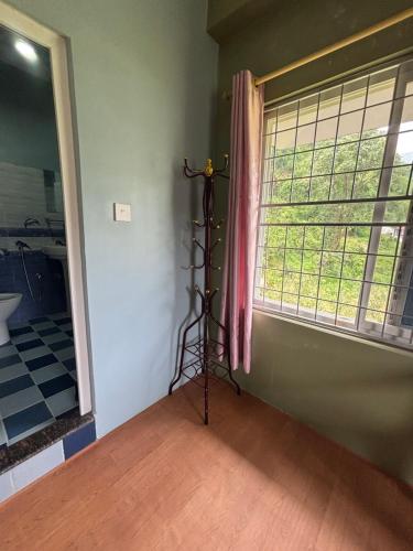 a room with a window with a pole in the corner at Unmani Yoga Retreat Pokhara in Pokhara