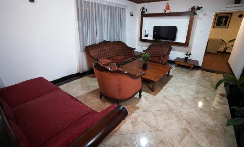 a living room with two couches and a tv at Weligama Bungalow in Weligama