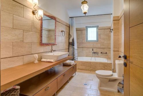 a bathroom with a sink and a toilet and a tub at Filistron Seaview Bliss - Coastal Secluded Gem in Taktikoúpolis