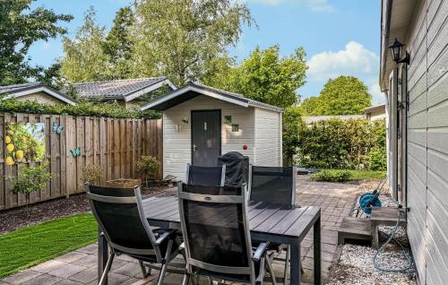 a wooden table and chairs on a patio at 2 Bedroom Nice Home In Ochten in Ochten