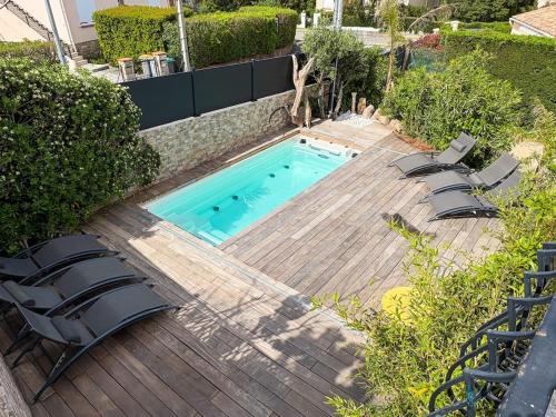 une piscine avec deux chaises et une table dans l'établissement Top of House, private Pool Spa 7 people, à Fréjus