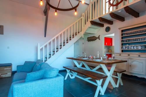 un salon avec une table et un canapé bleu dans l'établissement Ker Doudou - Ile Tascon, à Saint-Armel