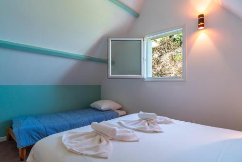 une chambre avec deux lits et une fenêtre dans l'établissement Ker Doudou - Ile Tascon, à Saint-Armel