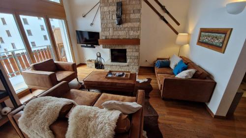 a living room with couches and a fireplace at Haus Serac in Saas-Fee