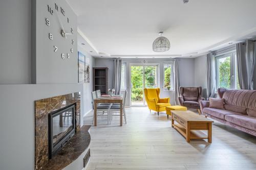 een woonkamer met een bank en een open haard bij Sunny Sobieszewo in Gdańsk