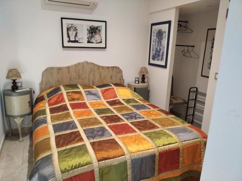 une chambre avec un lit avec une couette colorée dans l'établissement Dans Villa SUPERBE T2 INDEPENDANT, à Six-Fours-les-Plages