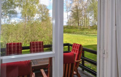 a balcony with a table and chairs looking out the window at 2 Bedroom Cozy Apartment In Mullsjö in Mullsjö