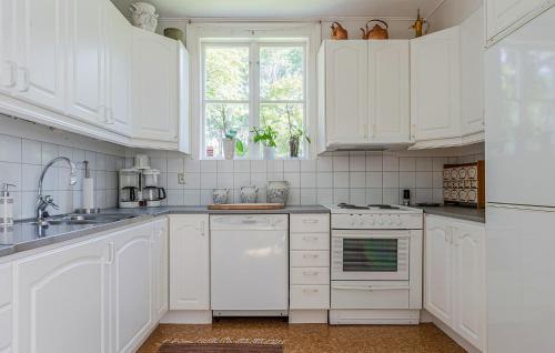 a white kitchen with white cabinets and a window at 2 Bedroom Cozy Apartment In Mullsjö in Mullsjö