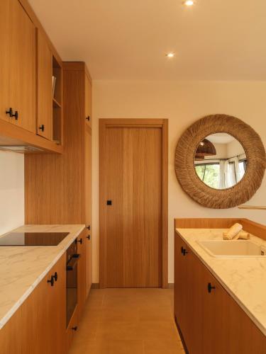 - une cuisine avec un évier et un miroir dans l'établissement Résidence Oradoro - Nouvel établissement, à Belgodère