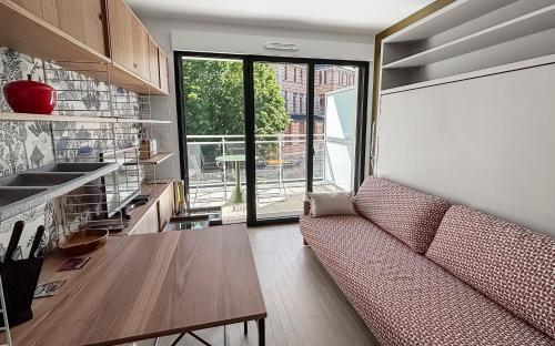 a living room with a couch and a table at Balcon calme, déco architecte & wifi ultra rapide in Sceaux
