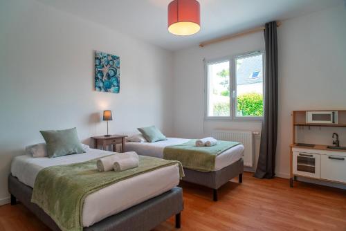 a bedroom with two beds and a window at La Bulle de Landrezac - Jacuzzi et Proche Plage in Sarzeau