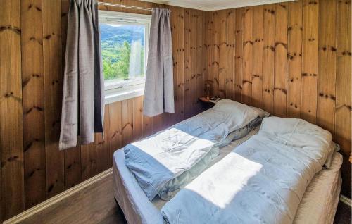 a bed in a wooden room with a window at Nice Home In Hafslo With Wifi in Hafslo