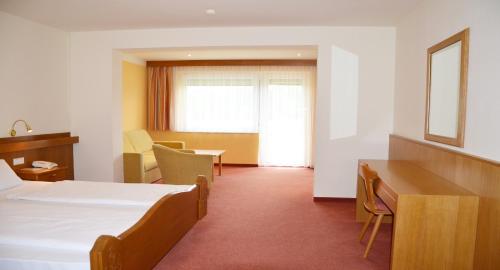 a hotel room with a bed and a desk at Hotel Fantur in Velden am Wörthersee