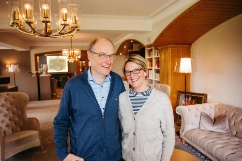 a man and a woman standing in a living room at Berghotel Hoher Knochen - Ruhe & Natur in Winterberg