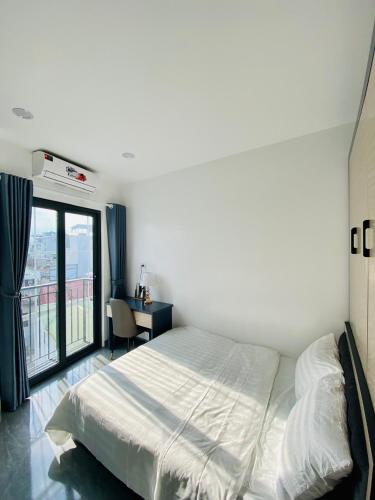 a bedroom with a bed and a desk and a window at Lilo's Homestay West Lake Thuy Khue in Hanoi