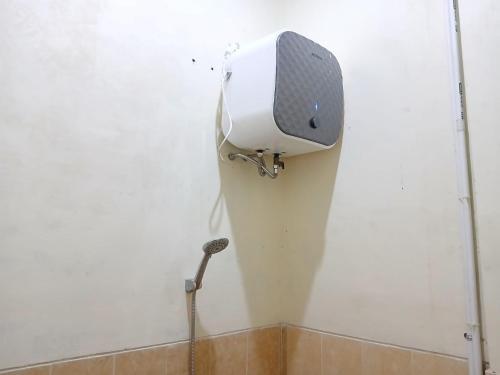 a shower in the corner of a white wall at RedDoorz Syariah near Masjid Al-Aqsha Klaten in Klaten