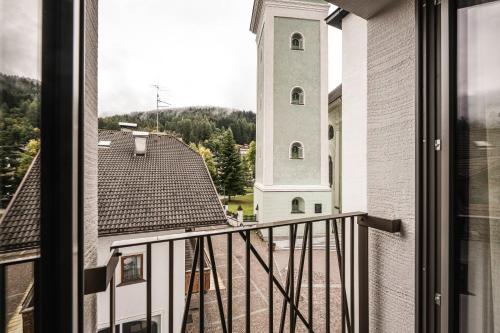 a view from a window of a building with a clock tower at The Post Apartments in Dobbiaco