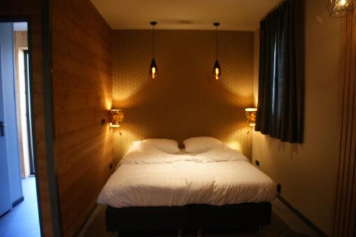 a bedroom with a bed with lights on the wall at Wellnesslodge Kievit in Dalerveen