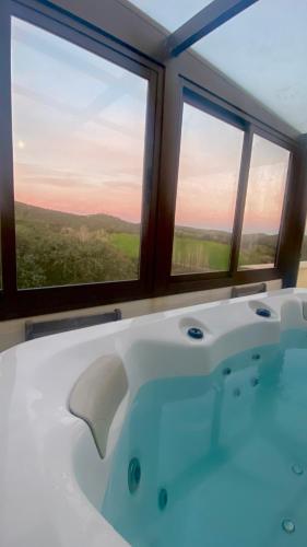 a bath tub in a room with two windows at La Siesta del Naranjo in Monesterio