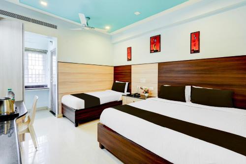 チェンナイにあるSuper Townhouse Chennai Near Airport Formerly Sai Bala Budgetのベッド2台、テーブル、デスクが備わる客室です。