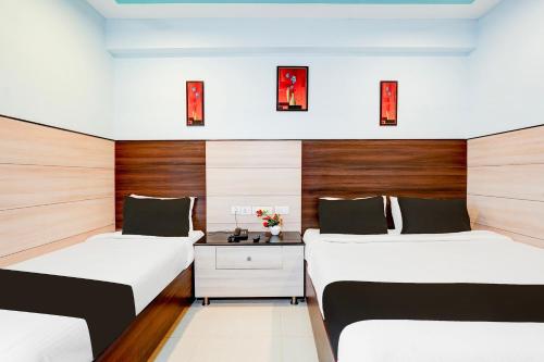 チェンナイにあるSuper Townhouse Chennai Near Airport Formerly Sai Bala Budgetのウッドパネルのドミトリールーム ベッド2台