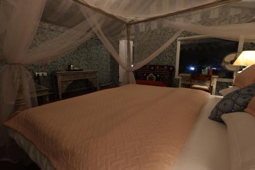 a bedroom with a white bed with a canopy at Vanaswara in Kolād