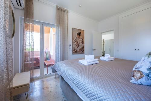 a bedroom with a bed with towels on it at DeCaNa Prestige Apartment - Gated Community Algarve in Porches