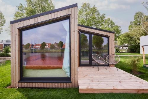 a tiny house with a large window and two chairs at Tetris Tiny House in Den Bosch